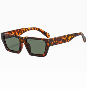 Detail der trendigen rechteckigen Schildpatt-Sonnenbrille mit dunkelgrünen Gläsern auf Weiß