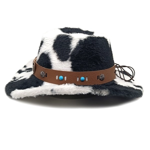 Détail d'un chapeau de cow-boy en peluche à motif vache avec bandeau en cuir marron