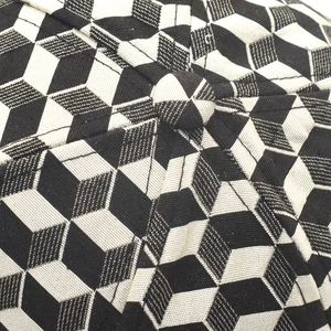 Close-up of baseball cap top showing black and white 3D cube pattern and fabric texture