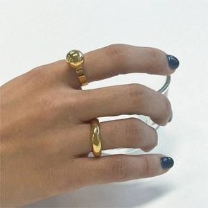 Close-up of minimalist gold-plated 925 silver rings with round bead and polished band