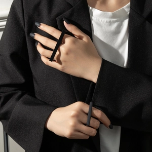 Hip-hop style long black metal double-finger ring worn on male hands for fashion look