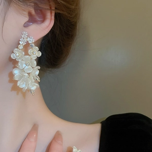 Elegant acrylic flower drop earrings with crystals shown on a model profile view