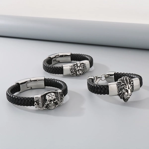 Close-up of woven leather bracelet with silver lion head and skull metal charms
