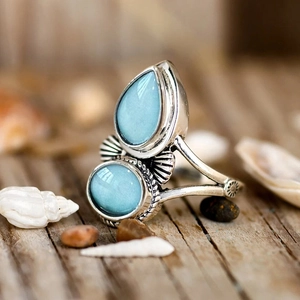 Vista macro di un anello d'argento vintage con due pietre azzurre e incisioni ornate