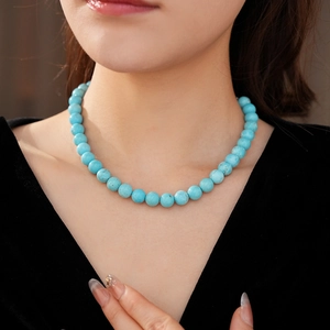 Close-up of minimalist turquoise beaded necklace on neck showing fine stone texture