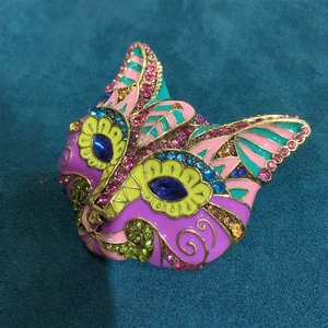 Detail of colorful enamel cat brooch featuring blue gemstone eyes and vibrant rhinestones
