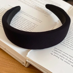 Padded black fabric headband with twill texture on a book for a vintage aesthetic look