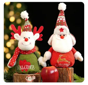 Detail of knitted Christmas figurines with reindeer and Santa designs on wood logs