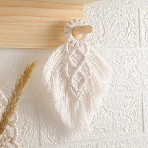 Detailed view of handmade cream white cotton rope woven feather wall hanging with fringes