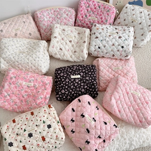 Detailed pile of quilted cotton makeup bags featuring floral and bear prints