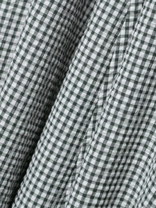Detailed close-up of green and white plaid seersucker fabric for midi dress