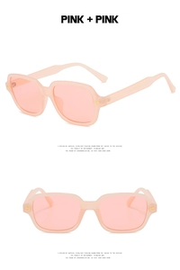 Detail of pink transparent square sunglasses frame with golden metal hinges and accents