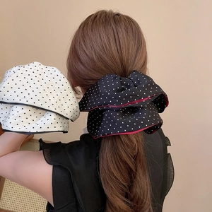 Detailed view of large polka dot fabric scrunchies in classic black and white patterns