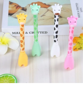 Four colorful giraffe cartoon gel pens standing on a wooden surface with lifestyle props