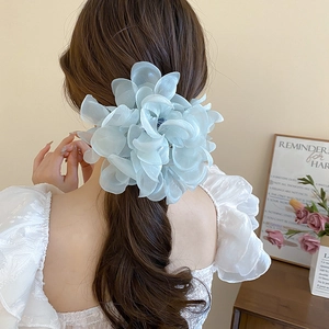 Detail of light blue lace flower hair claw with pearls worn on a ponytail