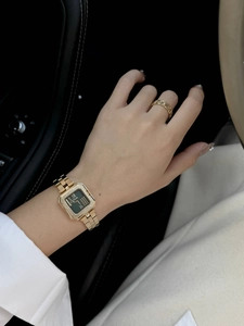 Dettaglio di un orologio quadrato da donna con quadrante verde e anello a catena d'oro