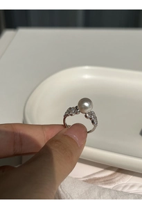 Macro detail of a silver lace ring featuring a grey pearl and sparkling side stones
