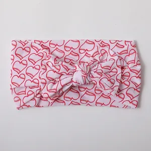 Detail of baby nylon headband featuring a large bow with red baseball heart patterns