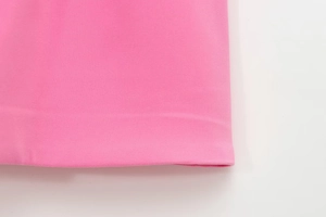 Detailansicht des gefalteten rosa Kleidsaums mit feiner Baumwollmischgewebe-Struktur