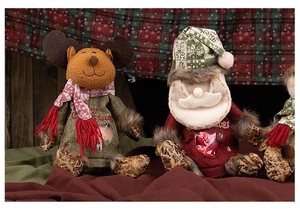 Detail of Christmas reindeer and Santa gift bags with heart windows on wood background