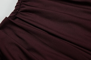 Vista macro della vita elastica a pieghe e della trama a maglia del vestito color bordeaux