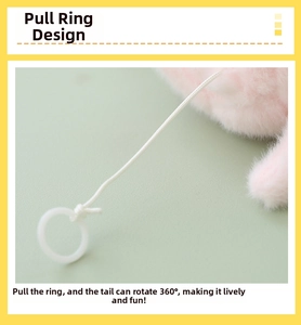 Detail showing the mechanical pull-ring design for rotating pink plush toy tail