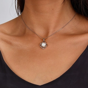 Detail of 925 sterling silver necklace with round white pearl pendant on model neck