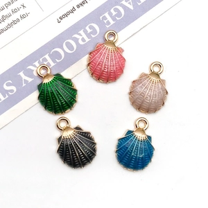 Macro detail of five colorful enamel shell charms with golden edges for jewelry making