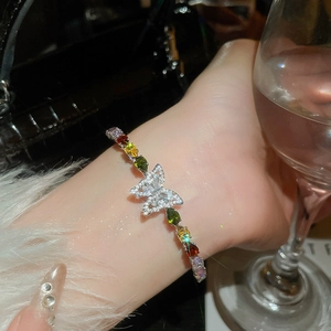 Dettaglio di un bracciale a farfalla in zircone con gemme colorate taglio a pera