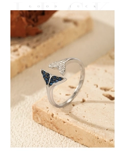 Macro detail of silver mermaid tail ring with blue and white sparkling crystals