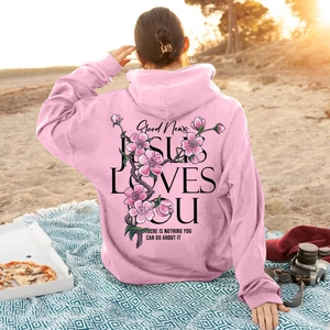 Pink cherry blossom hoodie with Jesus Loves You text print during a beach picnic