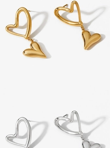 Macro detail of high-polish heart drop earrings in gold and silver stainless steel