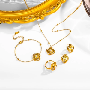 Golden windmill flower jewelry set with pearls including necklace and earrings on white