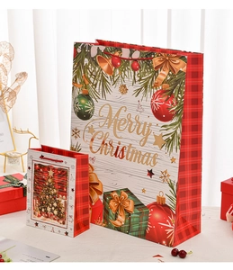 Close-up of Christmas gift bags with festive tree prints and Merry Christmas text