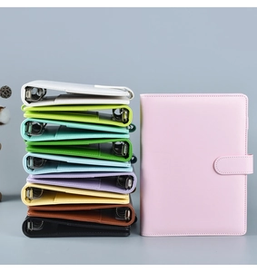 Detailed stack of colorful A6 PU leather binder notebooks with 6-ring mechanism and snap closure
