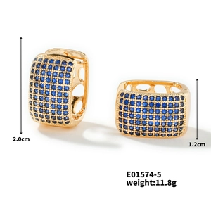 Detail view of wide C-shaped gold-plated hoop earrings with pave blue cubic zirconia