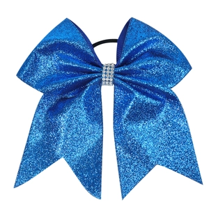 Detail of blue glitter hair bow with rhinestone center on white background