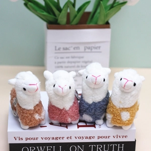 Set of four colorful plush alpaca keychains in brown pink blue and yellow colors