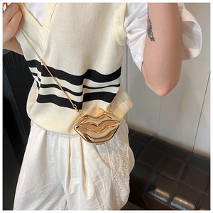 Detailed view of a gold metallic lip-shaped crossbody bag with a sleek chain strap