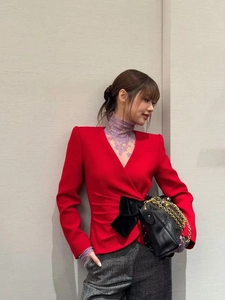 Detail of red deep V-neck top with oversized black velvet bow and elegant lace collar