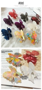Detail of elegant butterfly hair claws in acetate with marbled texture and bow design