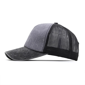 Close-up of gray washed denim and black mesh texture on a vintage trucker hat
