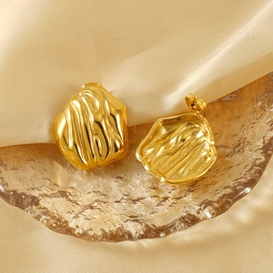 Irregular 18K gold plated stainless steel textured wave stud earrings on silk background