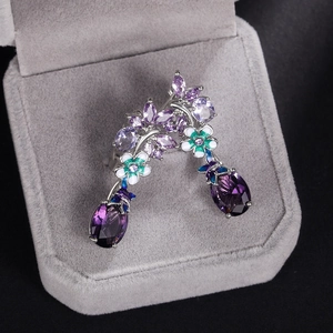 Detail of purple oval zircon flower earrings with enamel petals in a grey velvet gift box