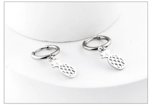 Detailed view of small pineapple pendant earrings in silver-toned stainless steel