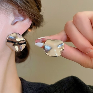Macro detail of silver irregular molten metal stud earrings with mirror polished finish