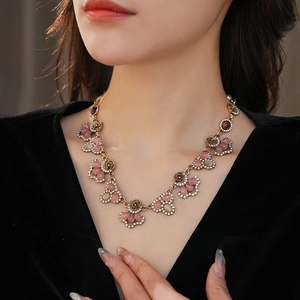 Detail of vintage palace style necklace with pink stones and diamonds on female model