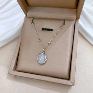 Detail of silver beaded chain necklace with oval moonstone pendant on silk