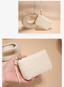Close-up of beige woven cotton rope coin purse with golden zipper and wrist strap