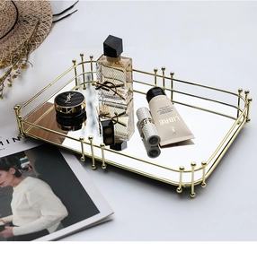 Détail d'un plateau rectangulaire en métal doré luxueux avec fond miroir et bords à billes